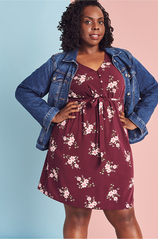 plus size woman in denim jacket and floral dress