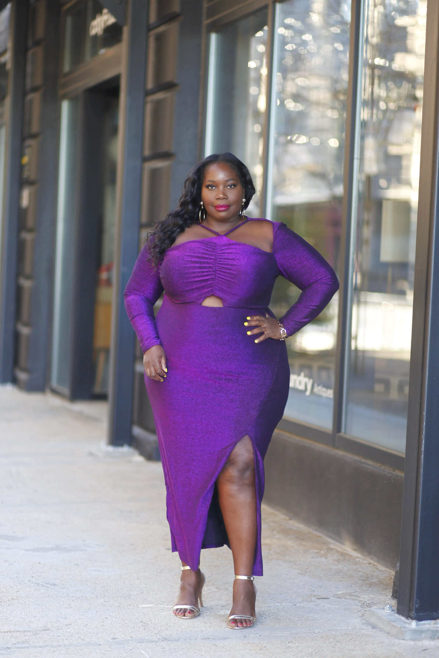 A purple shimmer plus size gown is perfect for a wedding guest or as a New Year's eve outfit. This has a thigh high split and cutouts in the dress.