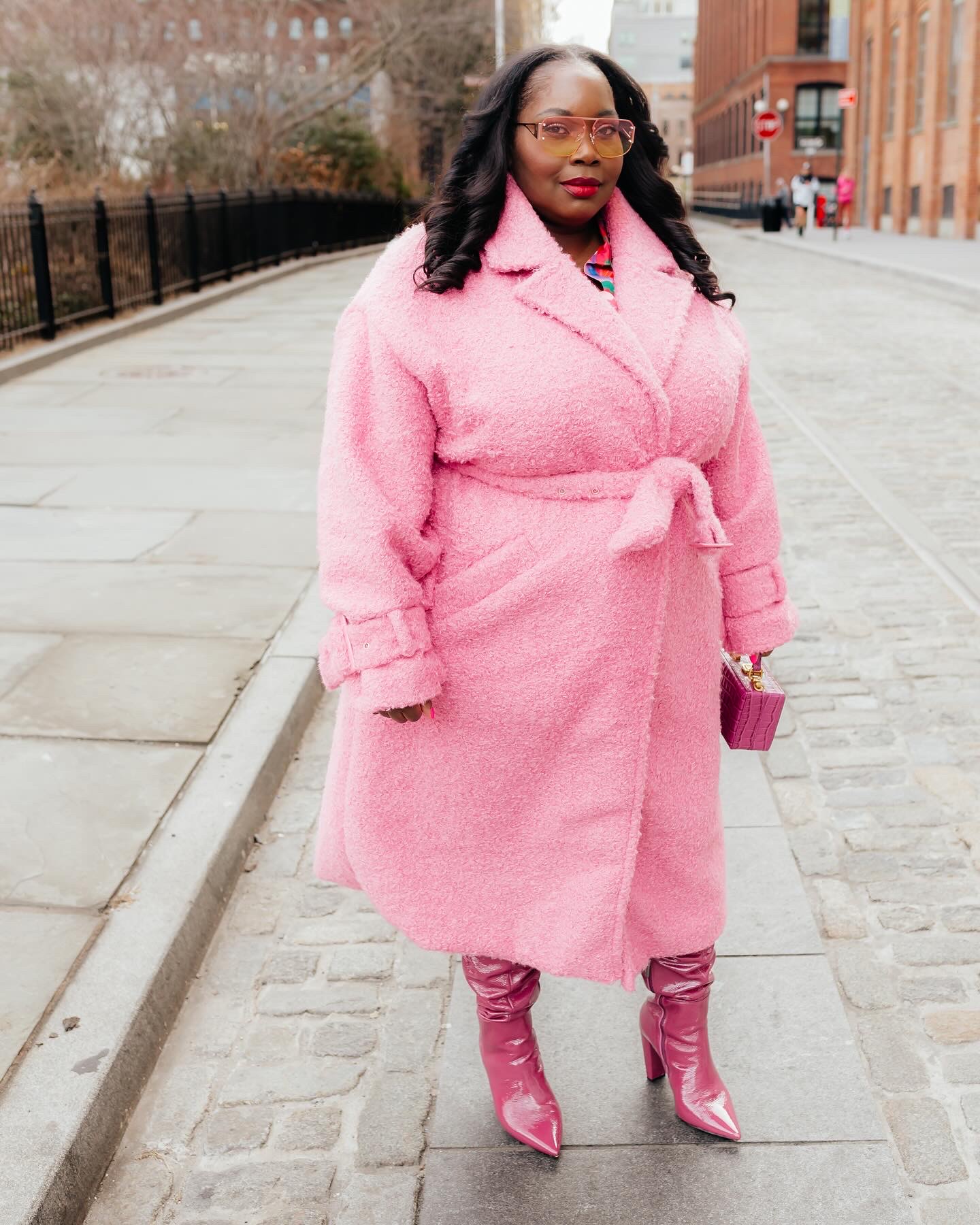 plus size winter outfit idea featuring a pink teddy coat and purple boots